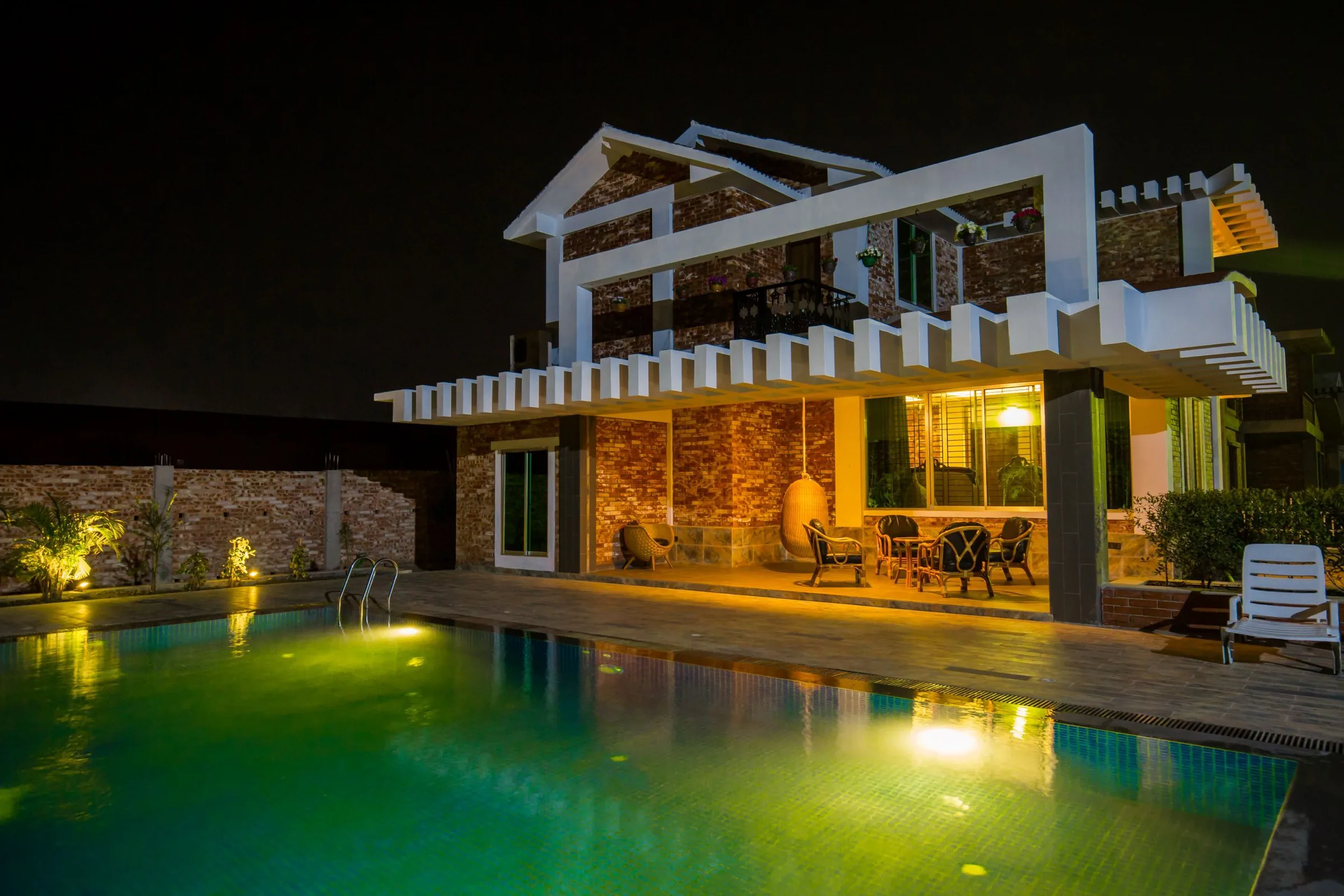 Illuminated modern house and swimming pool at night