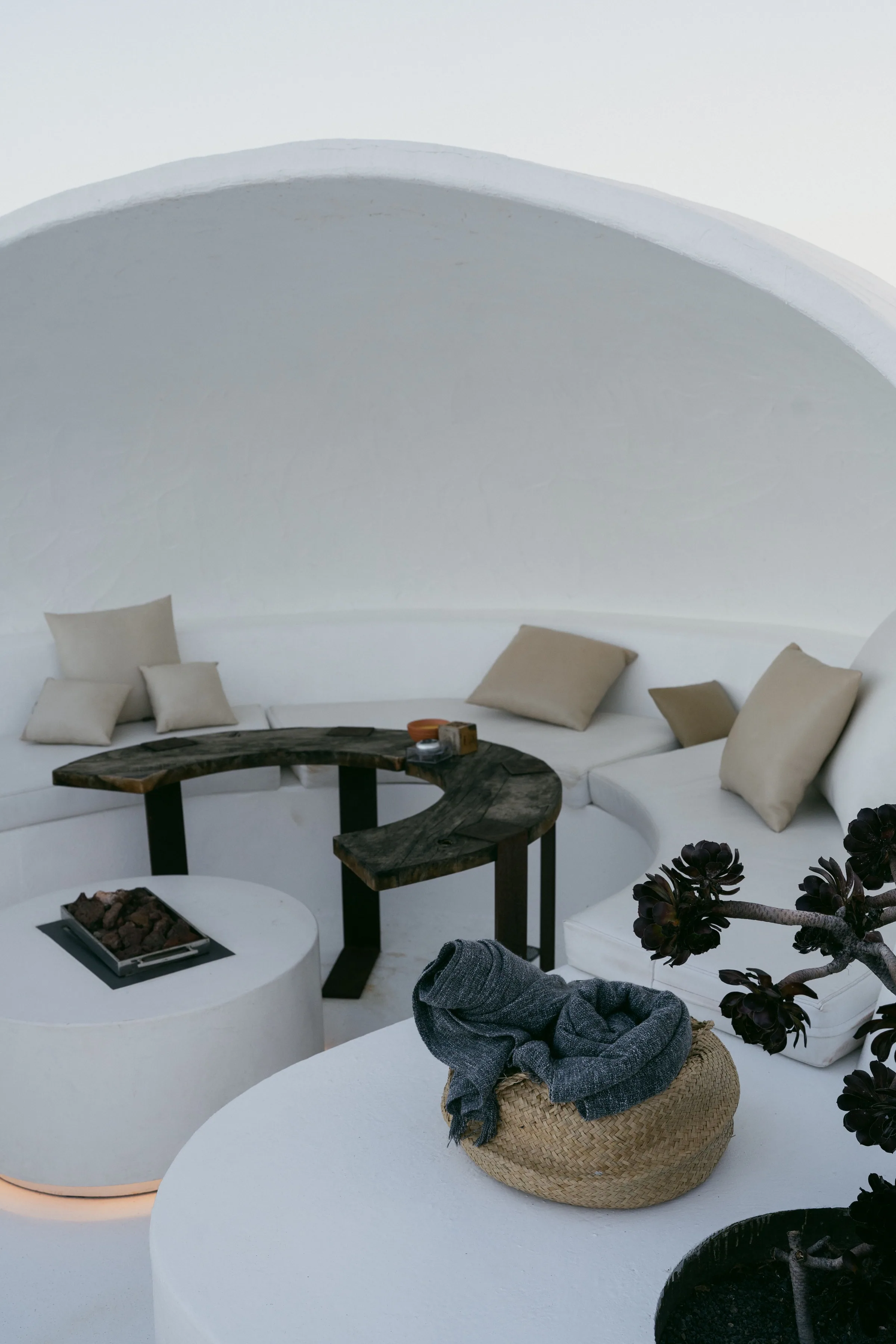 Minimalist neutral-toned interior with a curved wooden table